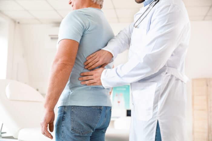 Urologist examining mature patient in clinic KIDNEY CANCER